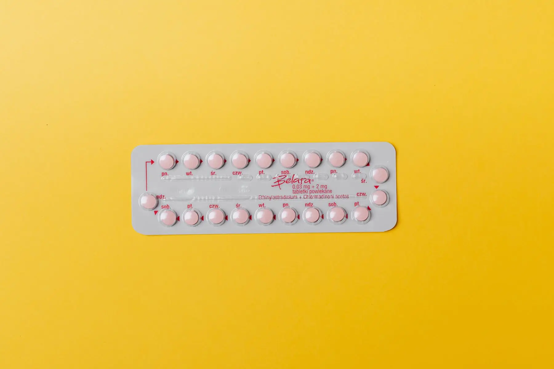 Blisterpackung mit rosa Tabletten auf gelbem Grund