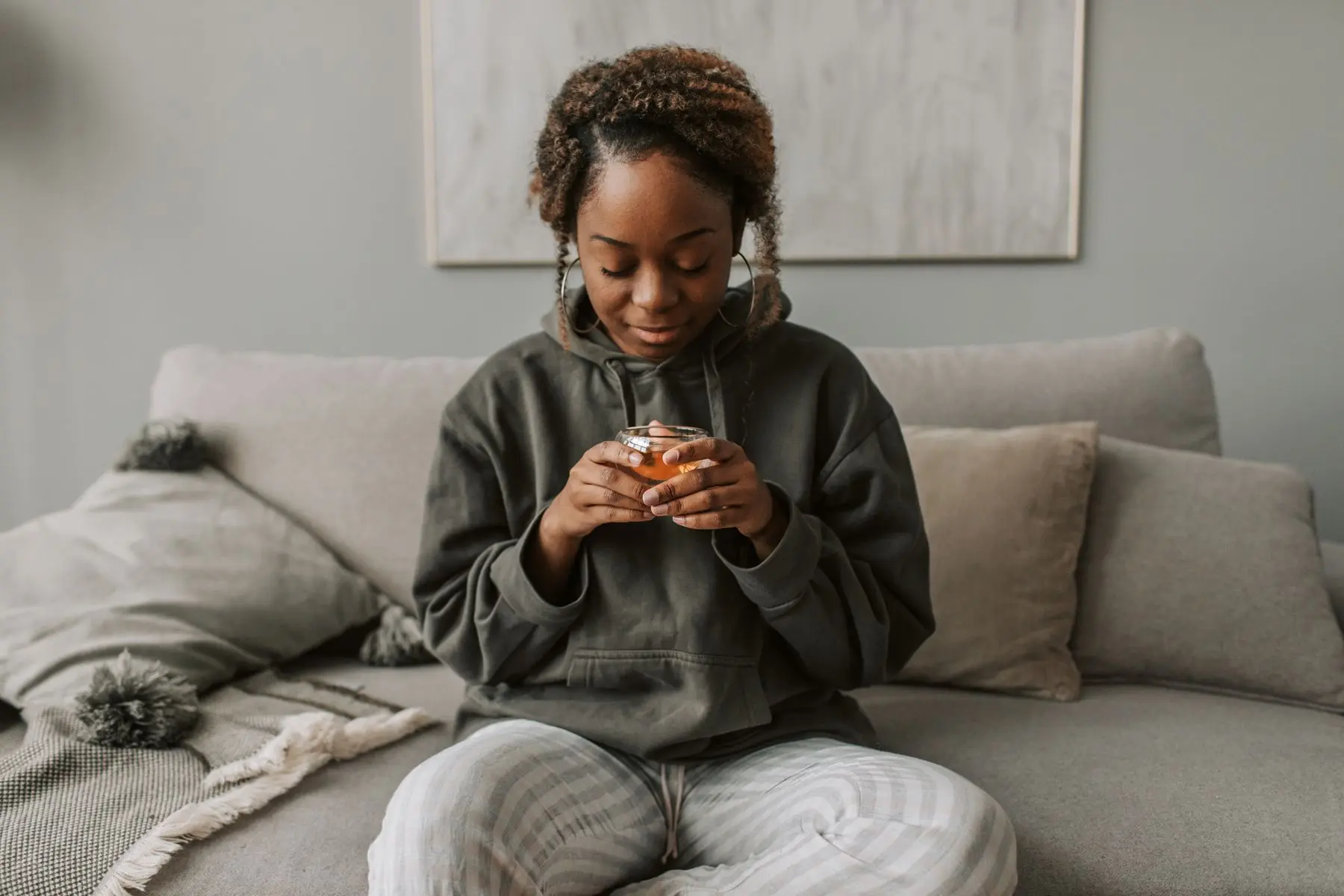 Frau mit Teetasse entspannt auf dem Sofa